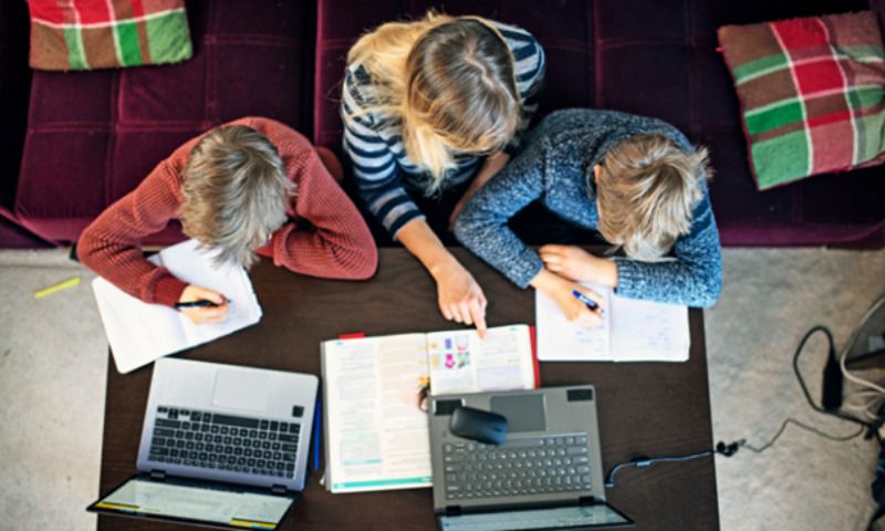 E-Learning für Kinder_Mama lernt mit zwei Kindern an Laptops
