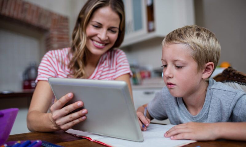Handschriftlich schreiben_Mutter lernt mit Kind mithilfe digitaler Medien
