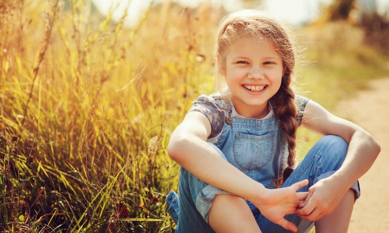 Eigenverantwortung fördern bei Kindern: Mädchen lacht in die Kamera