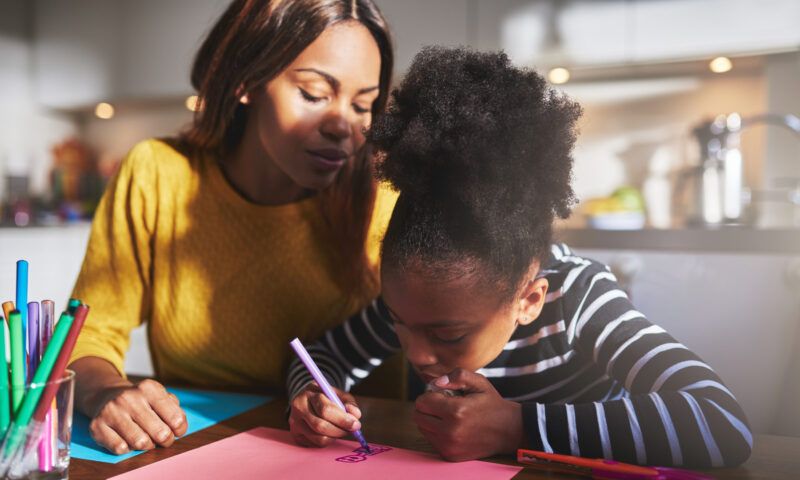 Online-Unterricht im Lockdown_Mutter hilft Tochter bei Hausaufgaben