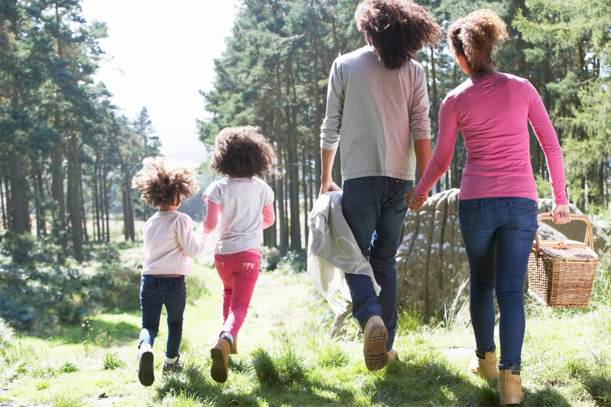Outdoor Aktivitaeten Kinder: Familie spaziert durch den Wald