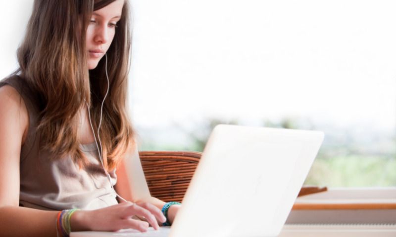 Pubertät und Schule: Teenie lernt online mithilfe von Laptop