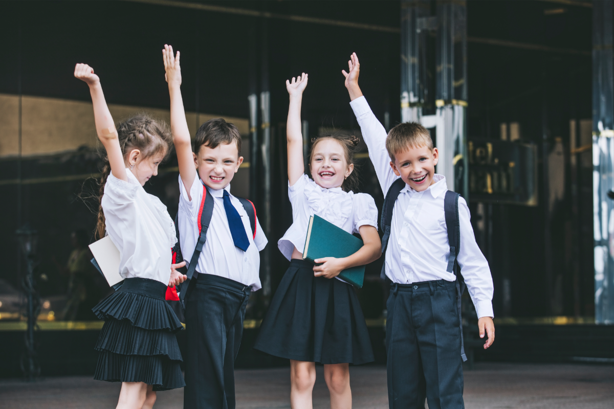 Wechsel weiterführende Schule_Schulkinder stehen zusammen und winken