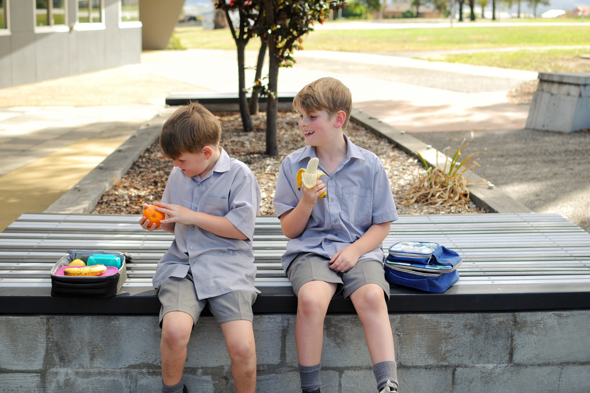 Nachhaltigkeit in der Schule: Jungs essen Mitgebrachtes in der Pause auf dem Schulhof