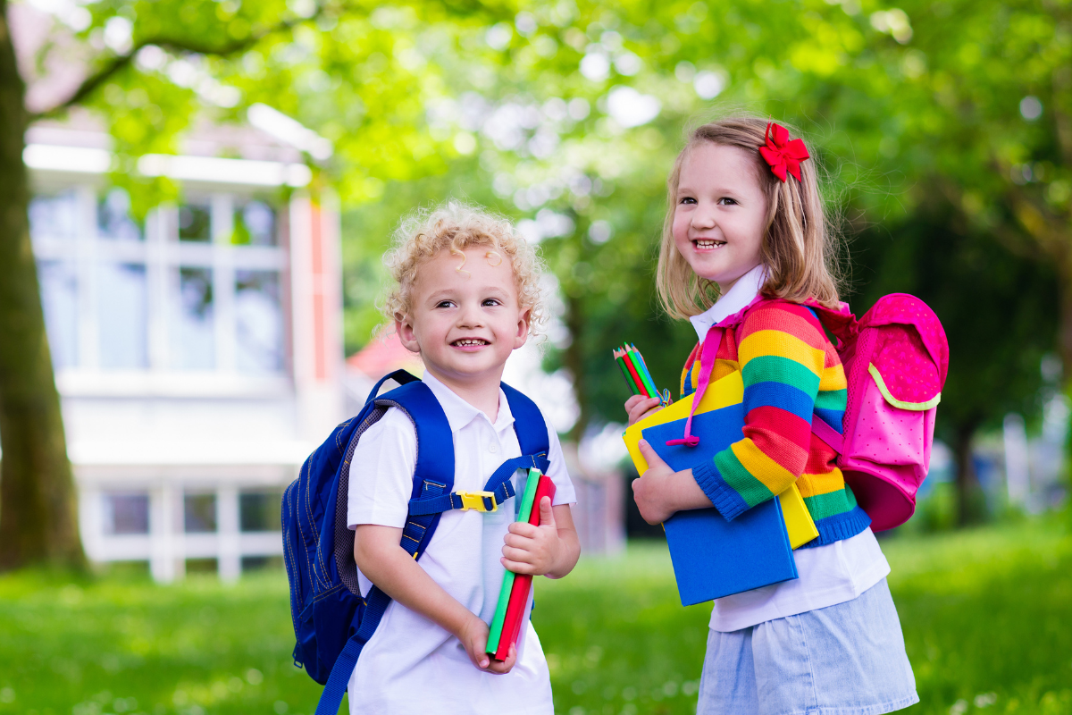 Schultuete Inhalt: Kinder mit Schulranzen und Stiften