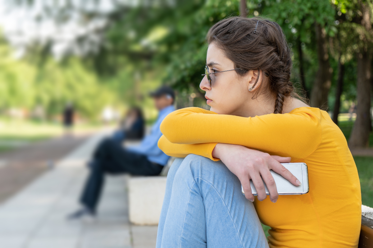 Tipps gegen Liebeskummer_Mädchen sitzt traurig auf Bank