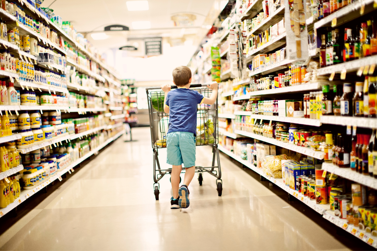 Inflation, Junge mit Einkaufswagen im Supermarkt