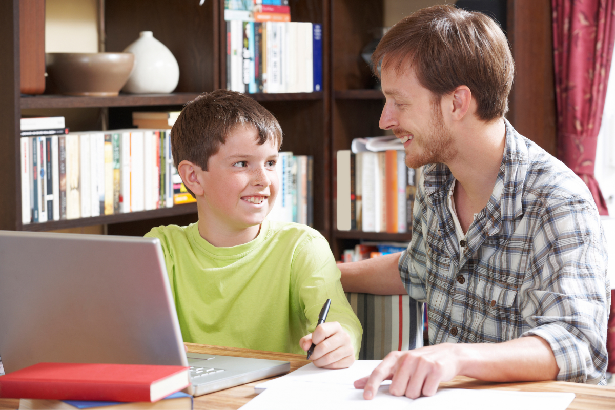 Sprachförderung in der Grundschule, Junge und Mann sitzen gemeinsam am Laptop
