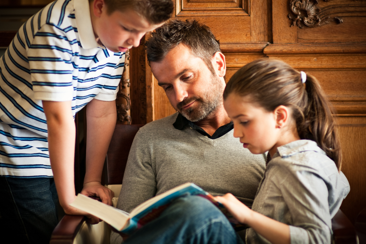 Sprachförderung in der Grundschule, Vater liest Kindern aus Buch vor