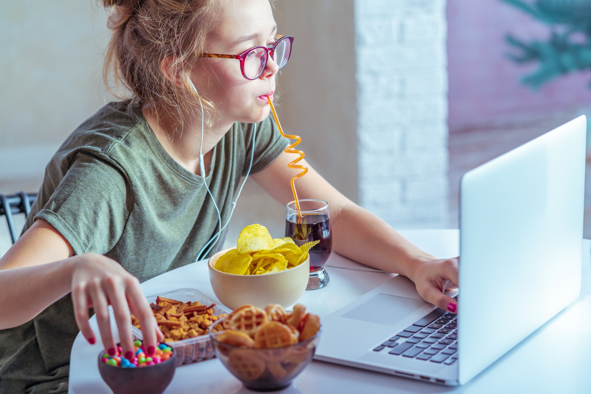 Ernährung und Gehirnleistung, Mädchen vor Laptop mit Süßigkeiten