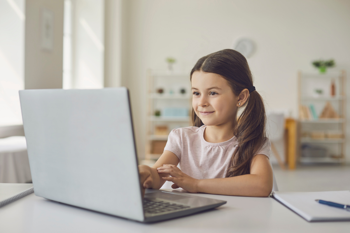 Schulzeugnis_Schulkind sitzt am Laptop und lernt für Prüfung