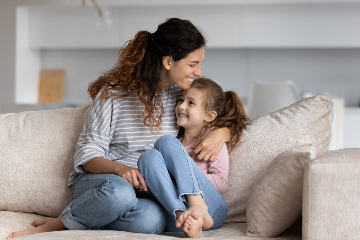 Erziehungsstile, Mutter und Tochter kuscheln auf dem Sofa