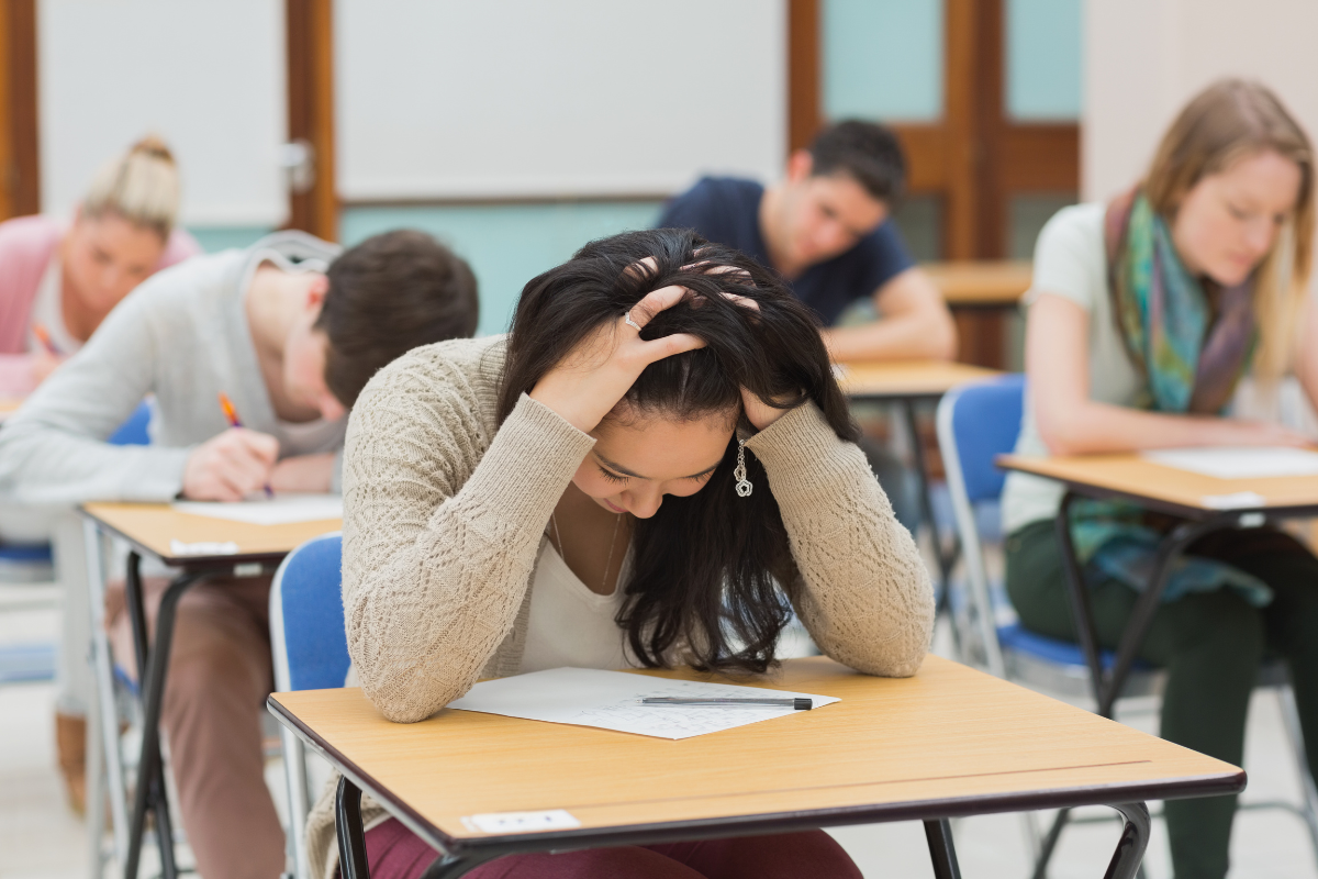 Last-Minute Abitur, Mädchen in Prüfung stützt Kopf auf Hände