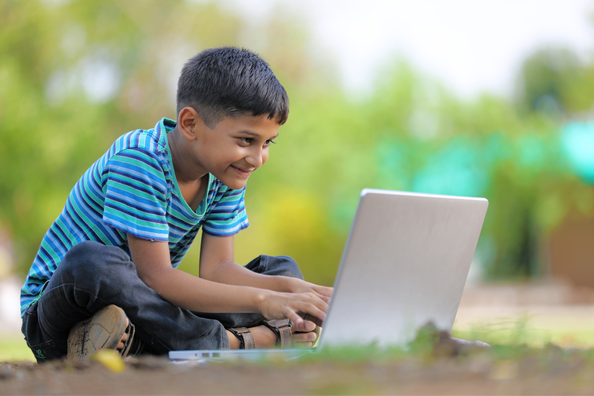 Pfingsten 2022, Junge sitzt mit Laptop draußen