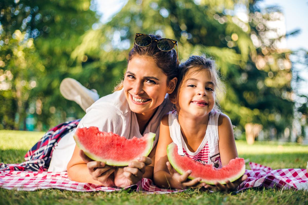 Weltvegetariertag - Mutter und Tochter essen Melone draußen