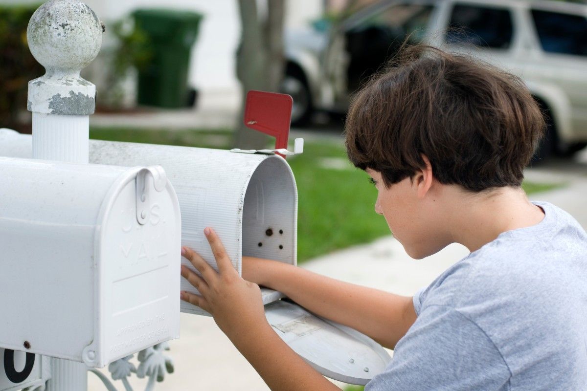 Post an den Osterhasen: Junge schaut in Briefkasten