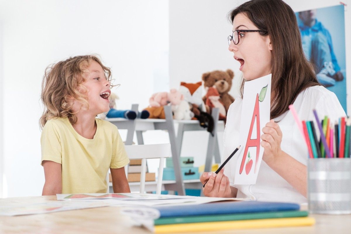 Stottern bei Kindern: Logopaedin mit Schuelerin