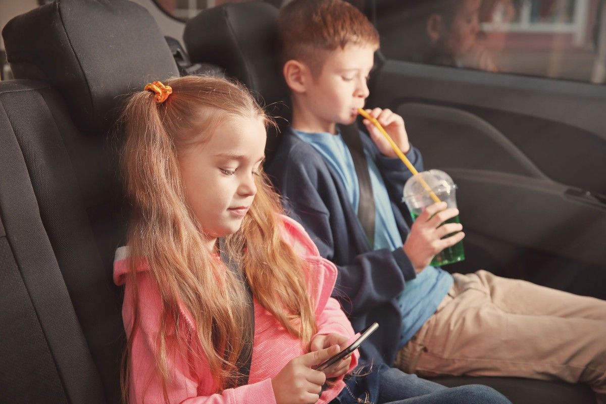 Reisespiele: Kind mit Handy im Auto