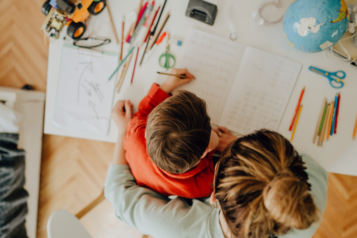 homeschooling in der grundschule_Junge und Mutter lernen gemeinsam am Schreibtisch