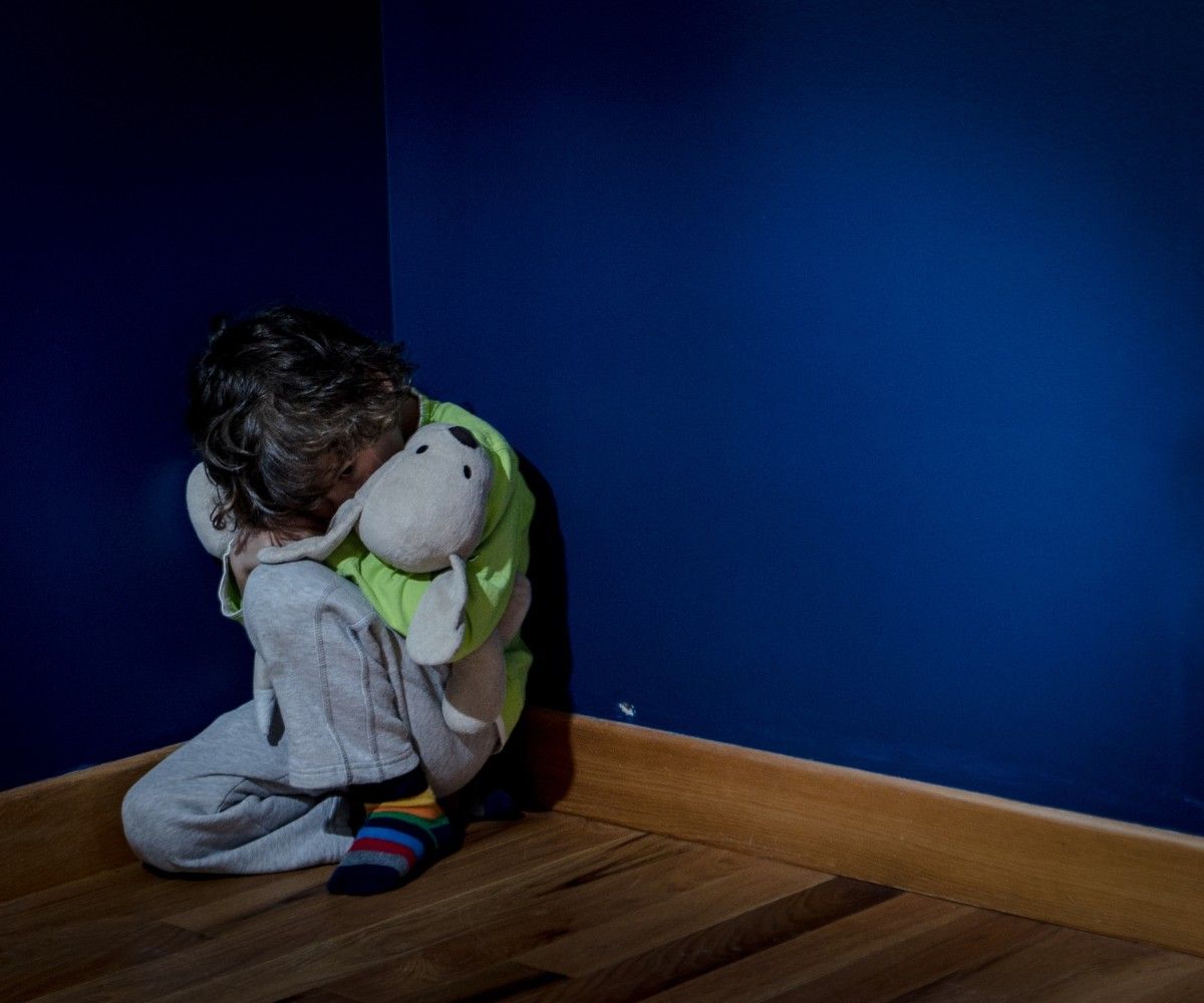 Aengste bei Kindern: Kind sitzt aengstlich in Ecke