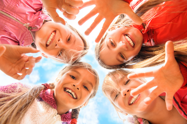 Selbstständigkeit bei Kindern fördern: Mädchen lachen in die Kamera