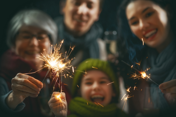 Vorsaetze fuer das neue Jahr: Familie mit Wunderkerzen
