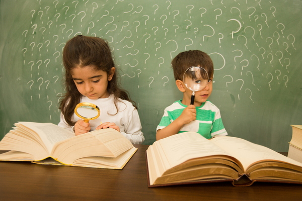 Lernschwaeche: zwei Kinder mit Lupe und Buch