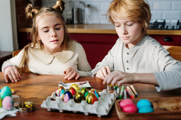 Ostereier Ausblasen, Junge und Mädchen mit bunten Ostereiern