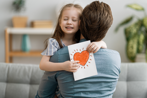 Vatertagsgeschenk 2022, Mädchen umarmt Vater