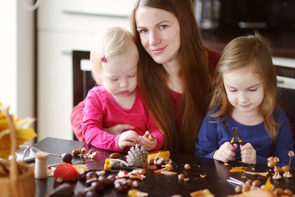 Basteln mit Kastanien_Mutter basteln mit zwei Mädchen am Küchentisch