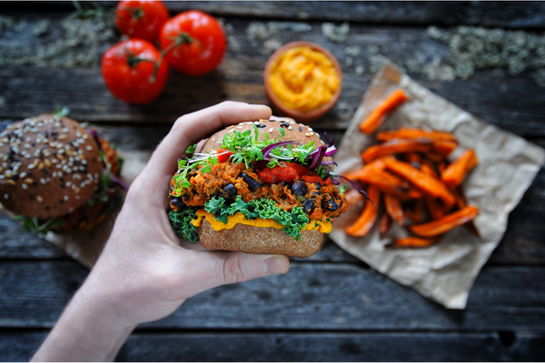 Vegane Ernährung_Hand hält einen veganen, saftigen Burger