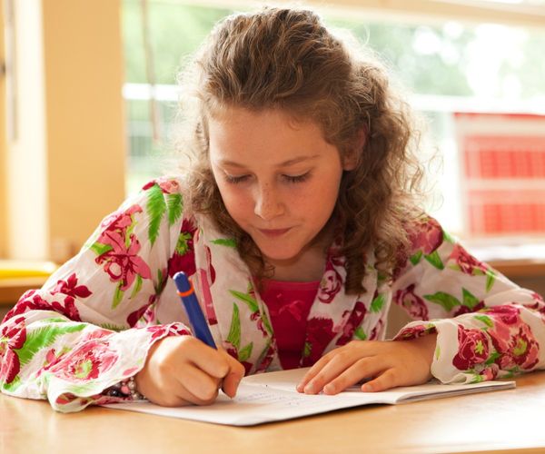 Lernzettel erstellen: Kind schreibt in Schulheft