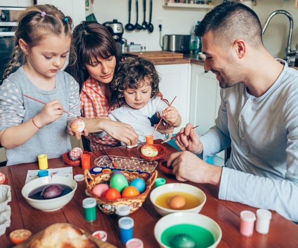 Ostern mit Kindern: Familie bemalt Ostereier