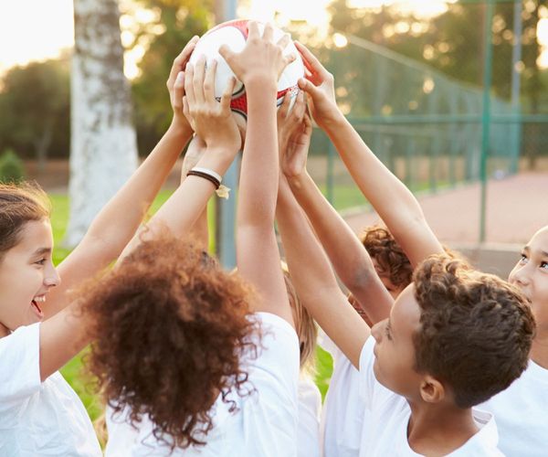 Sport und Schule vereinbaren: Schueler mit Fußball